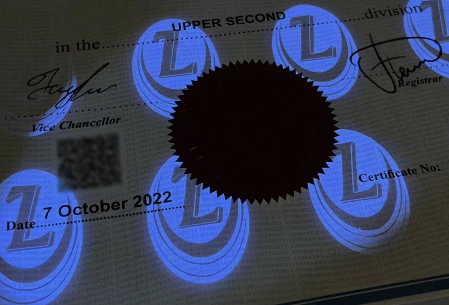 Macro photograph of secure certificate under UV light revealing glowing holographic L seals, microtext, and QR verification