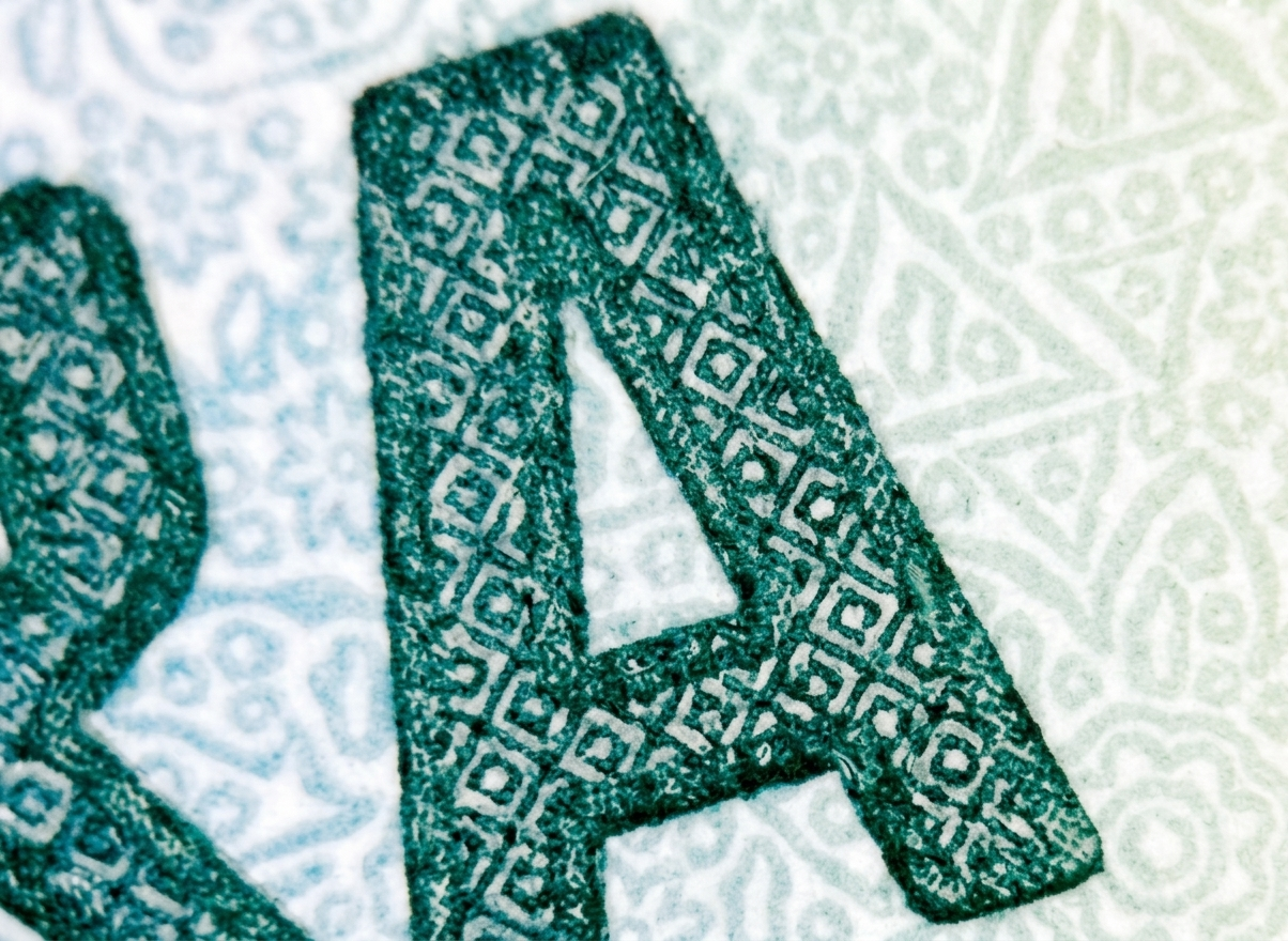 Macro photograph of microtext guilloche patterns on security certificate paper